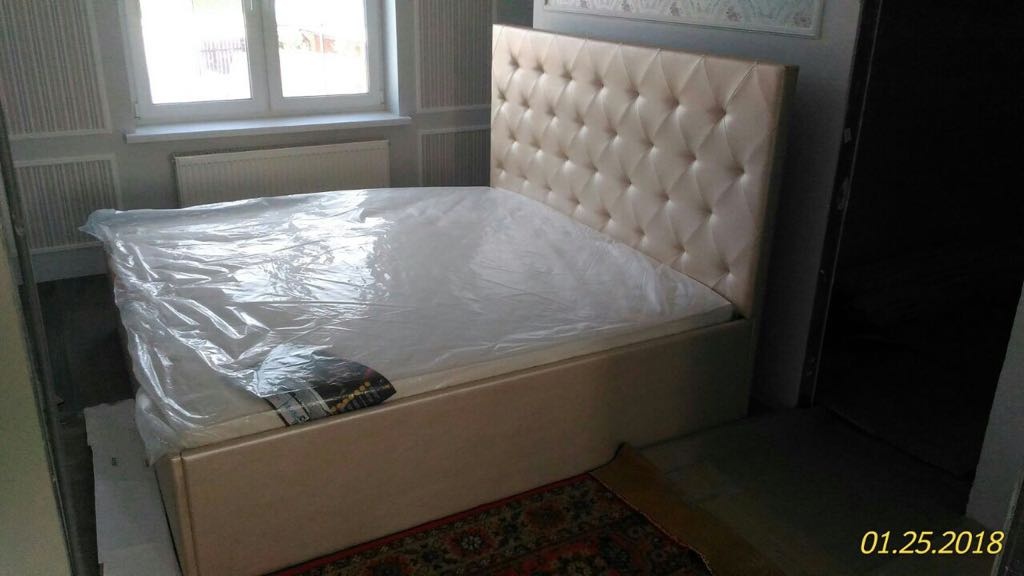 Установка бежевой двуспальной кровати
