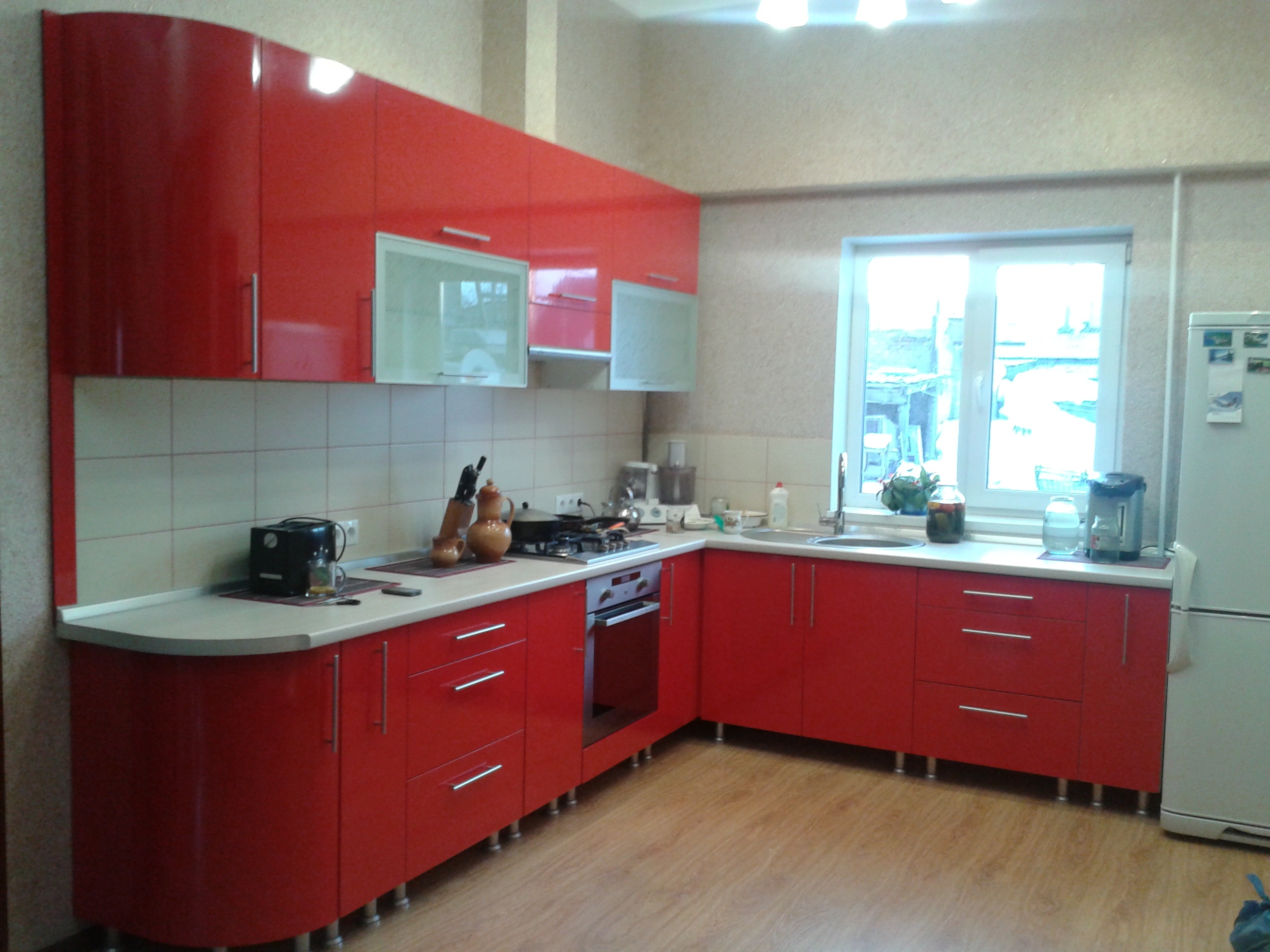 Красная угловая кухня с радиусными фасадами